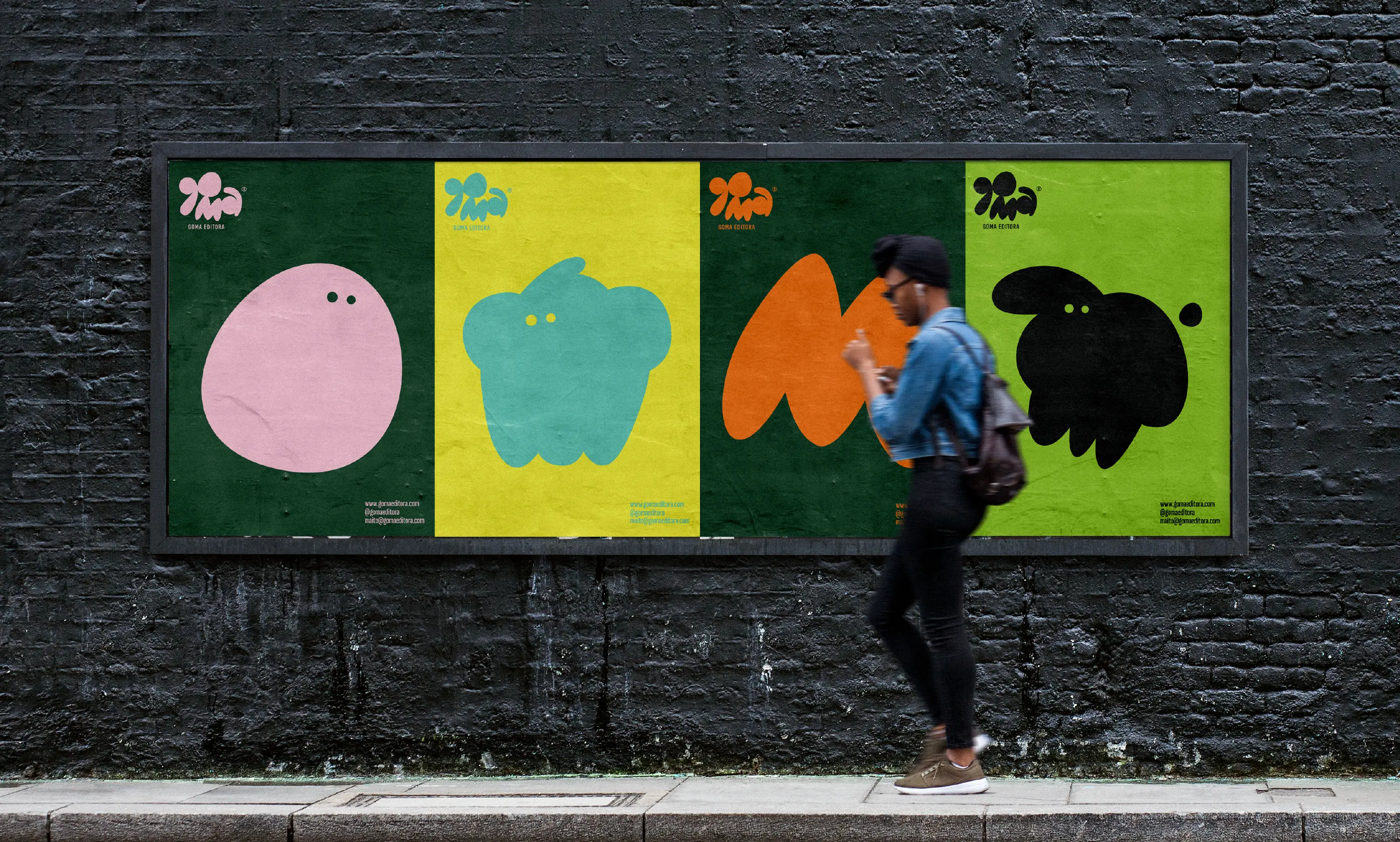 Goma campaign posters with colorful abstract characters on a brick wall.