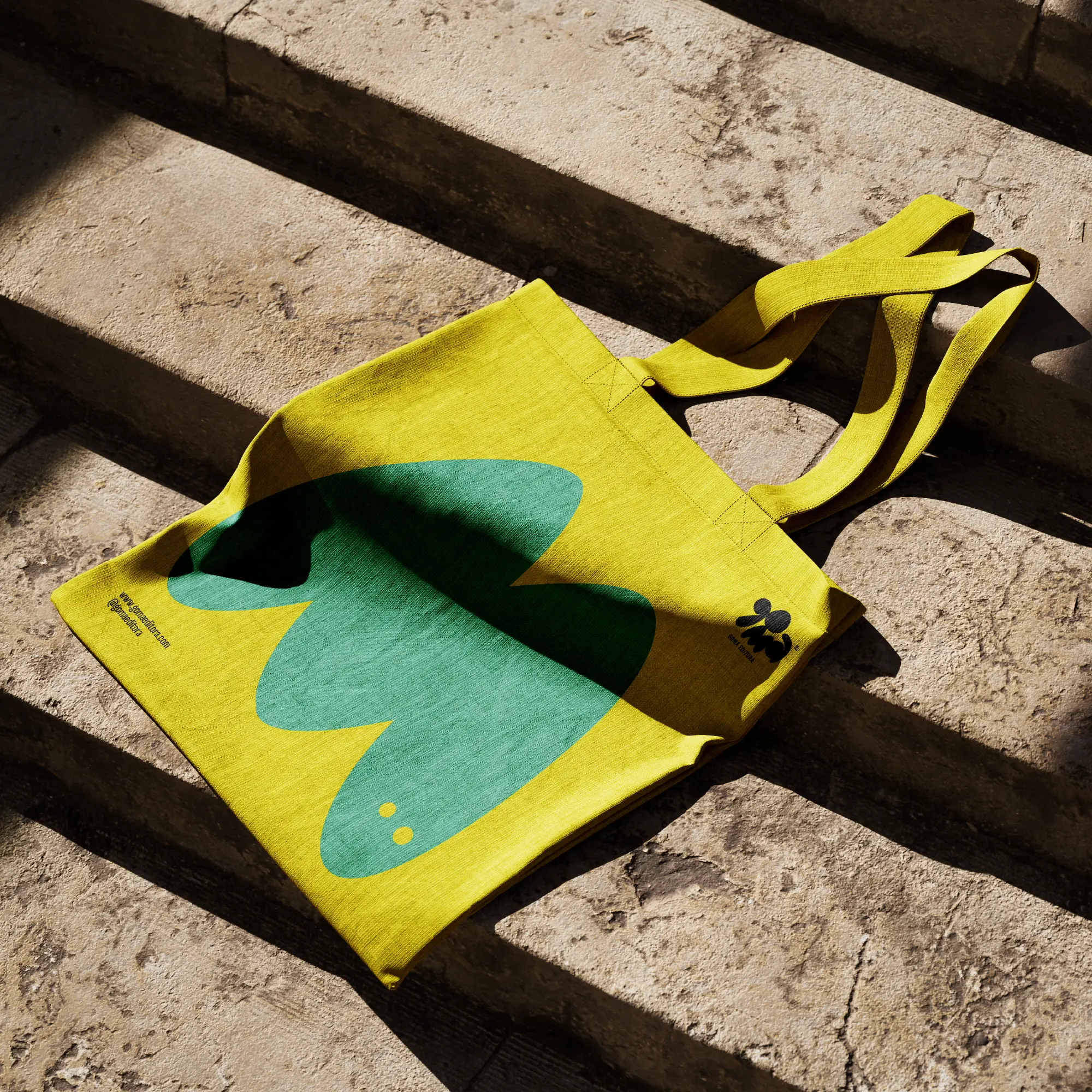 Yellow tote bag printed with a green Goma character.