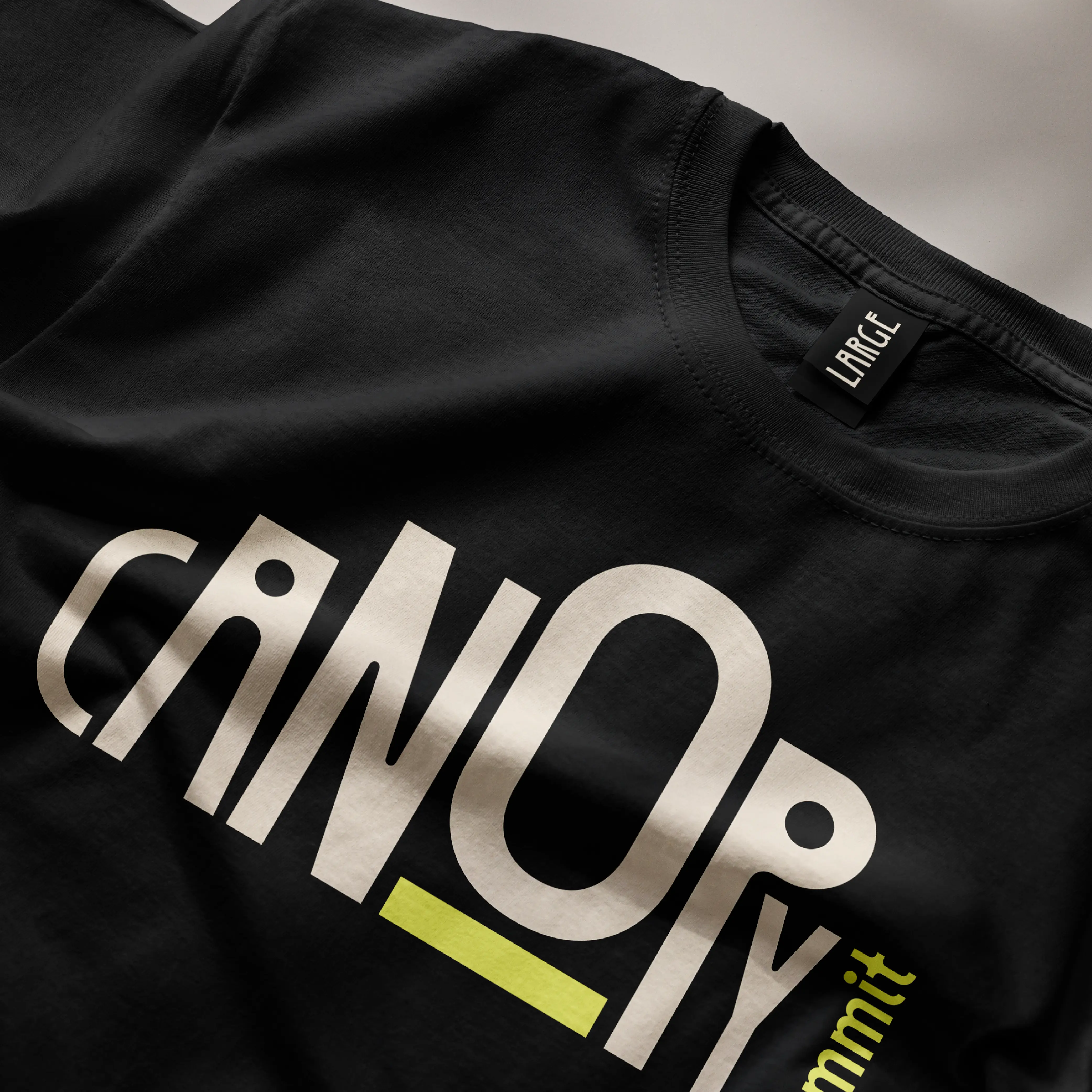 Black T-shirt detail printed with Canopy event lettering.
