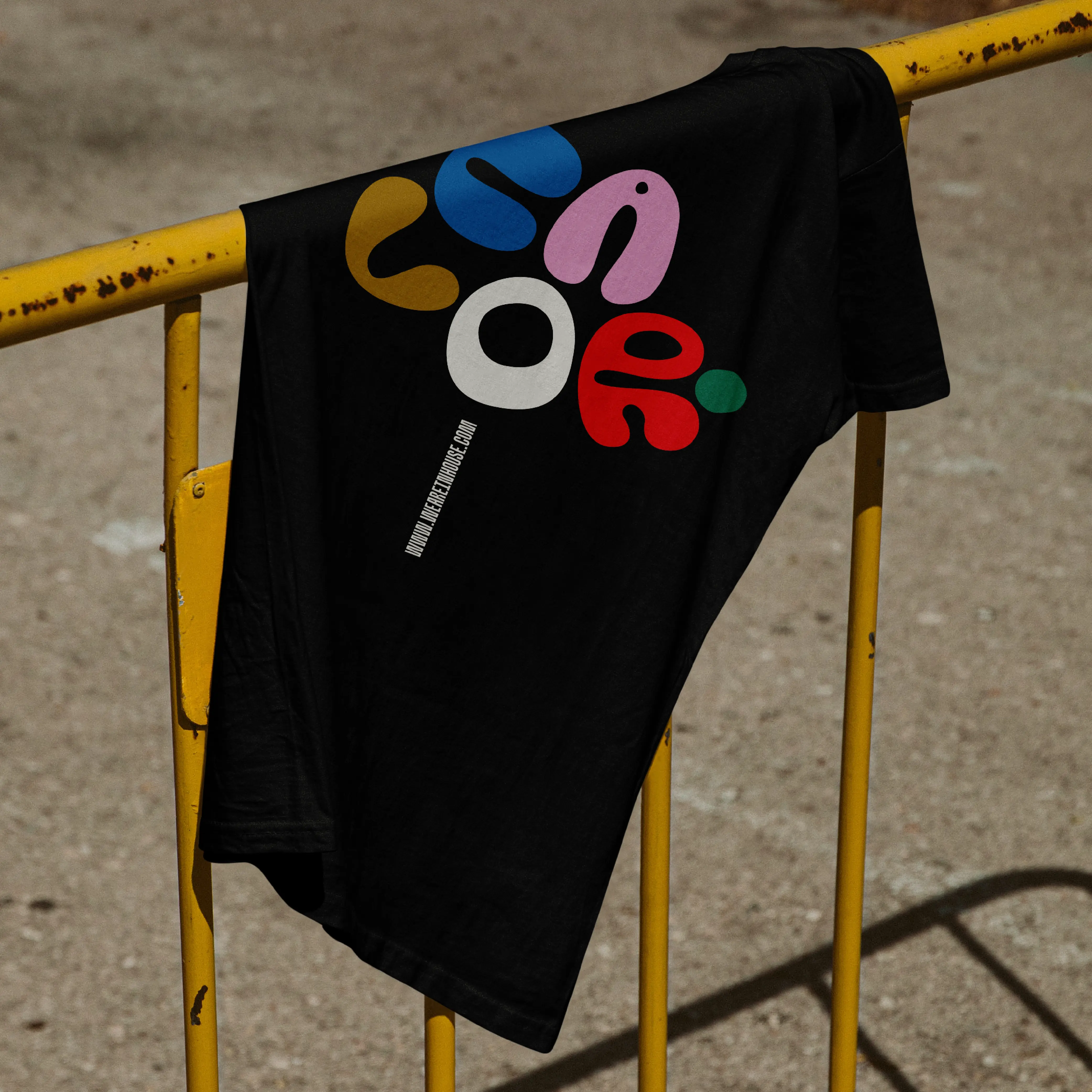 Black T-shirt over a railing printed with Brinca letterforms.