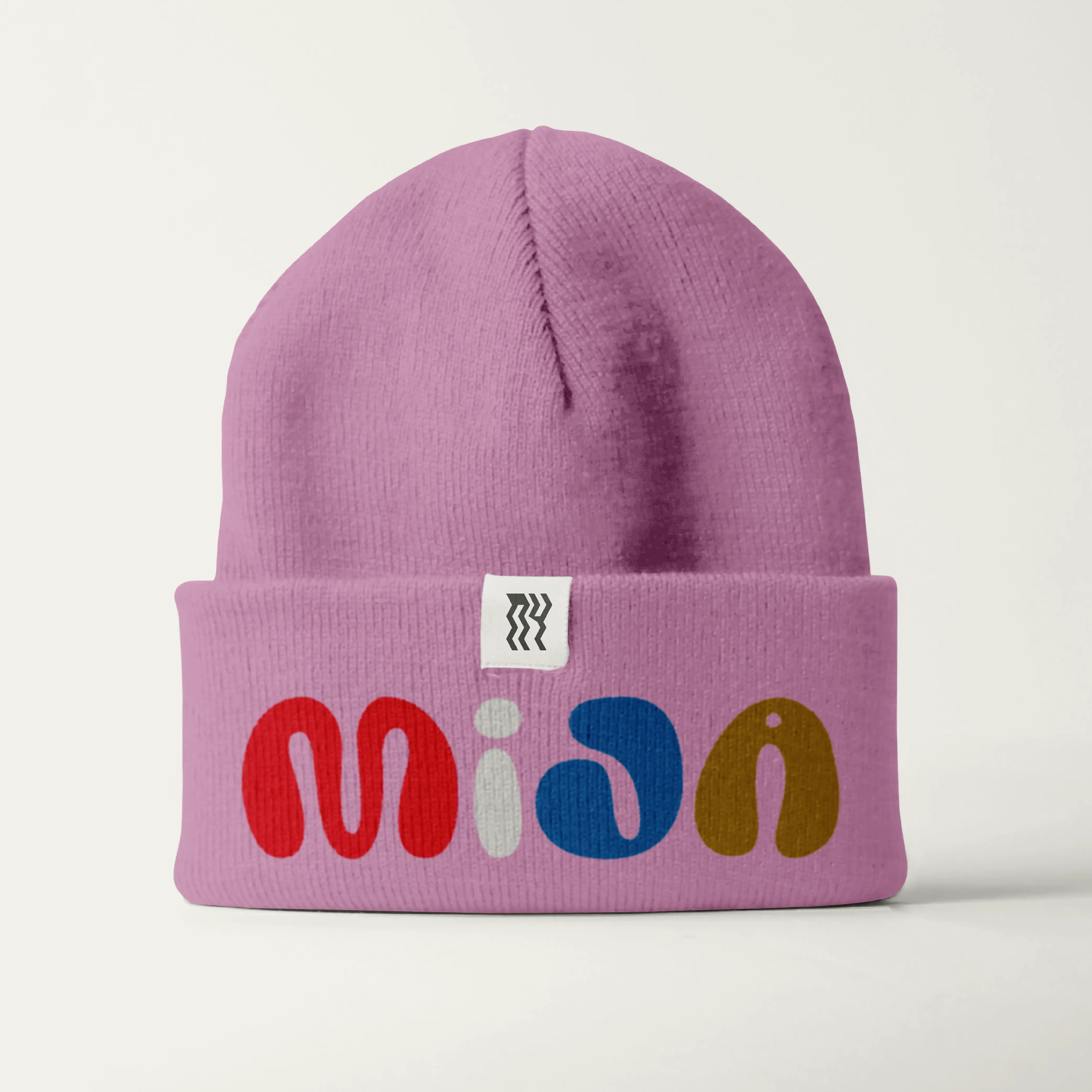Pink beanie with a folded label using Brinca lettering.